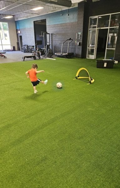 Physical Development Center Kid Kicking a Ball into a Goal